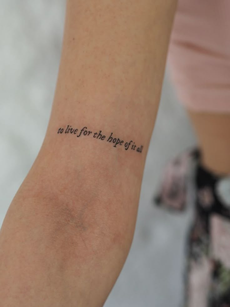 a woman's arm with a tattoo that reads, in time for the happy holidays