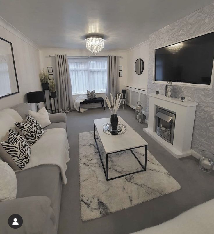 a living room filled with furniture and a flat screen tv mounted on the wall above a fire place