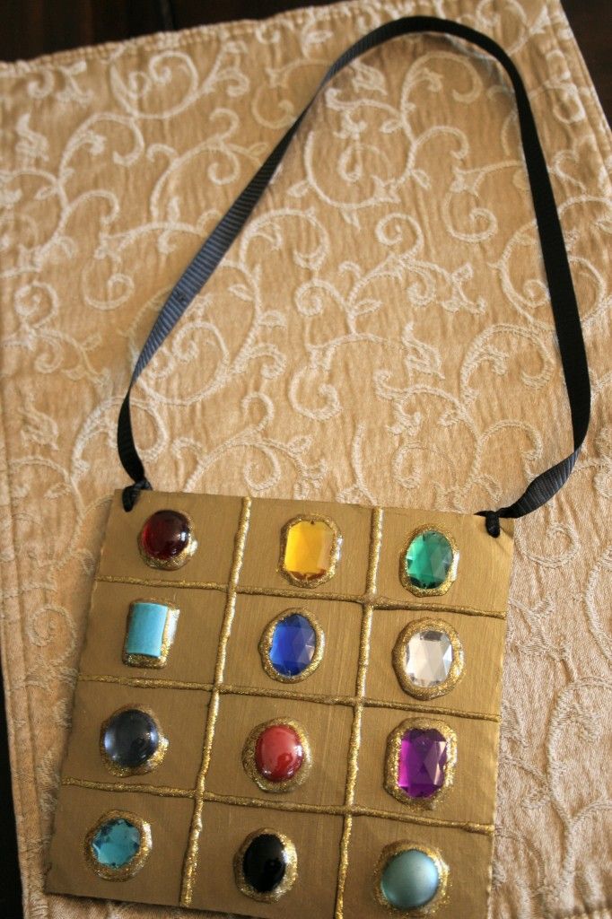 a handbag that is sitting on top of a bed with many different colored stones