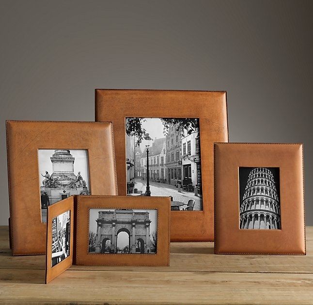 four different frames are sitting on a wooden table, one is empty and the other has an old photo in it