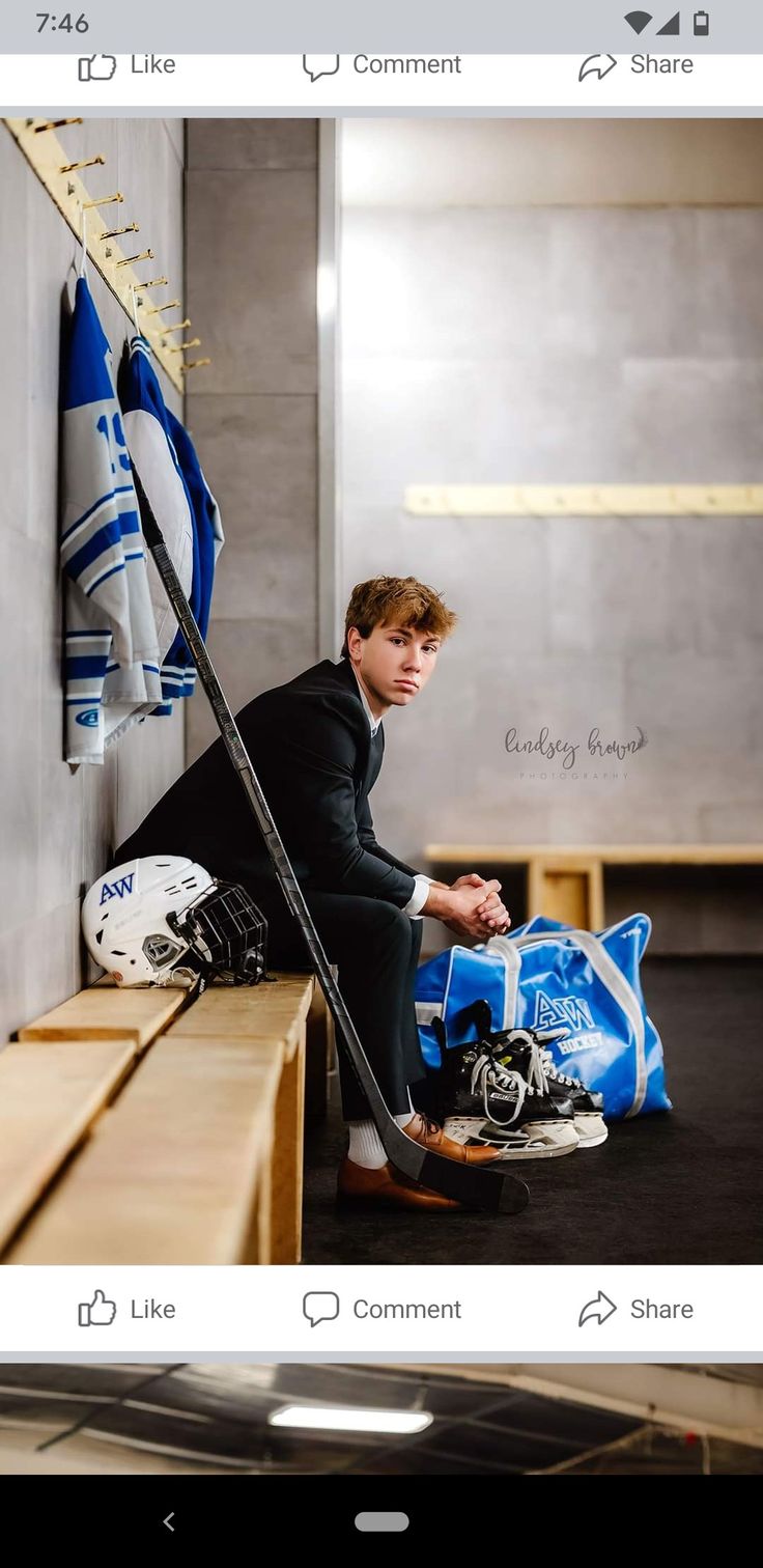 a man sitting on top of a bench next to a hockey goalie's helmet