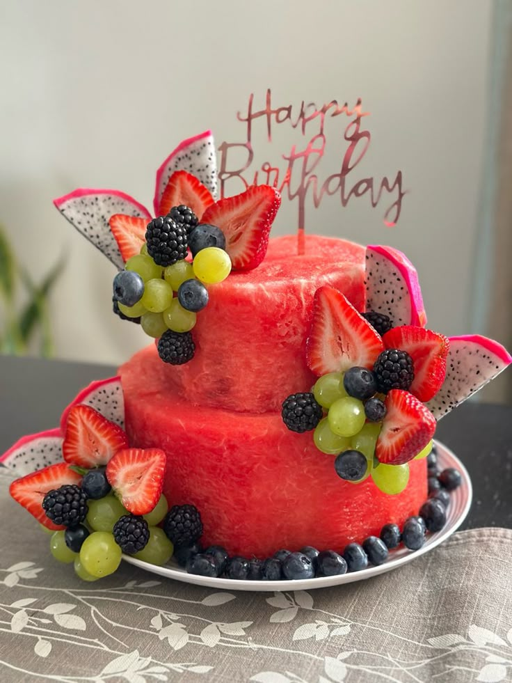 a birthday cake decorated with fruit and candles