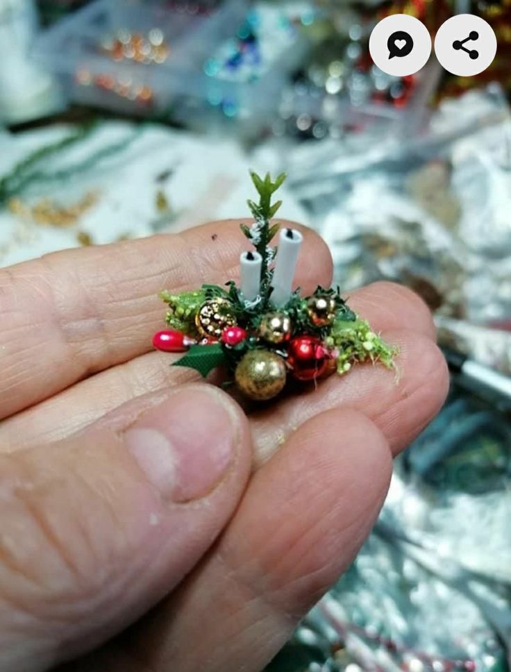 someone is holding a tiny christmas tree ornament