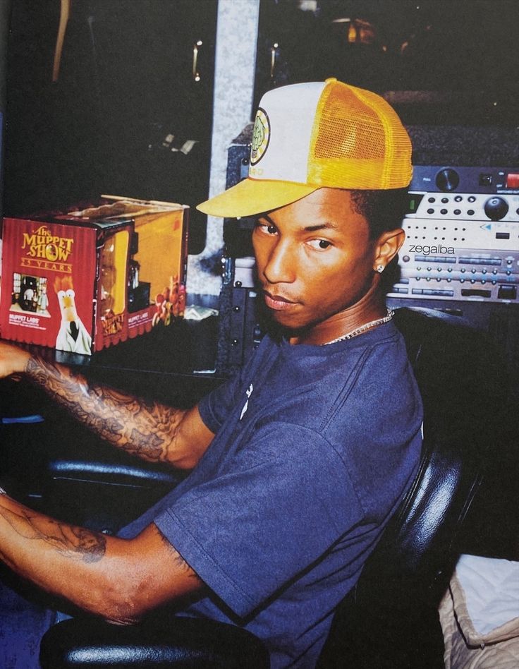 a man sitting in a chair with a yellow hat on his head and holding a box