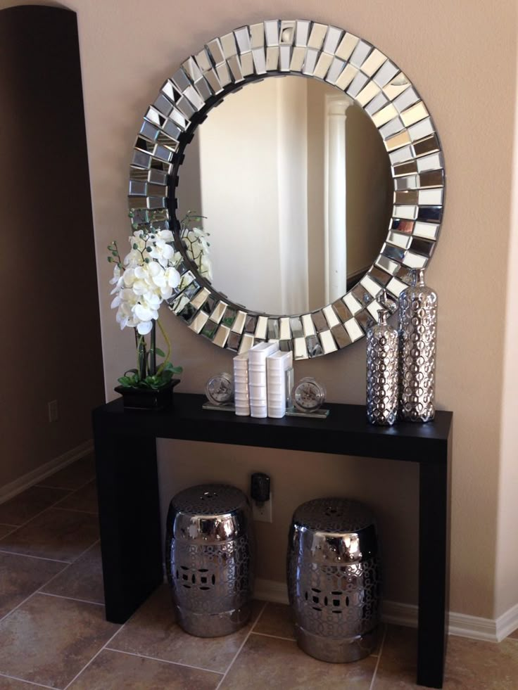 there is a mirror and vases on the table in this living room with tile flooring