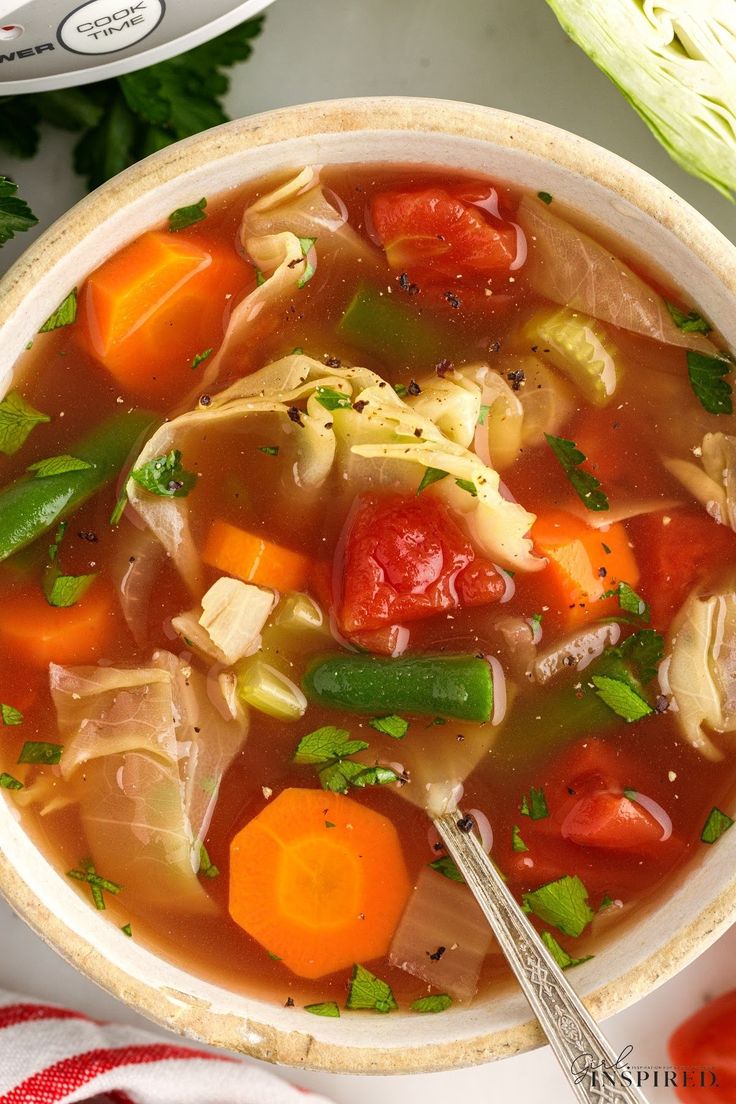 a bowl of soup with carrots, celery and other vegetables in it