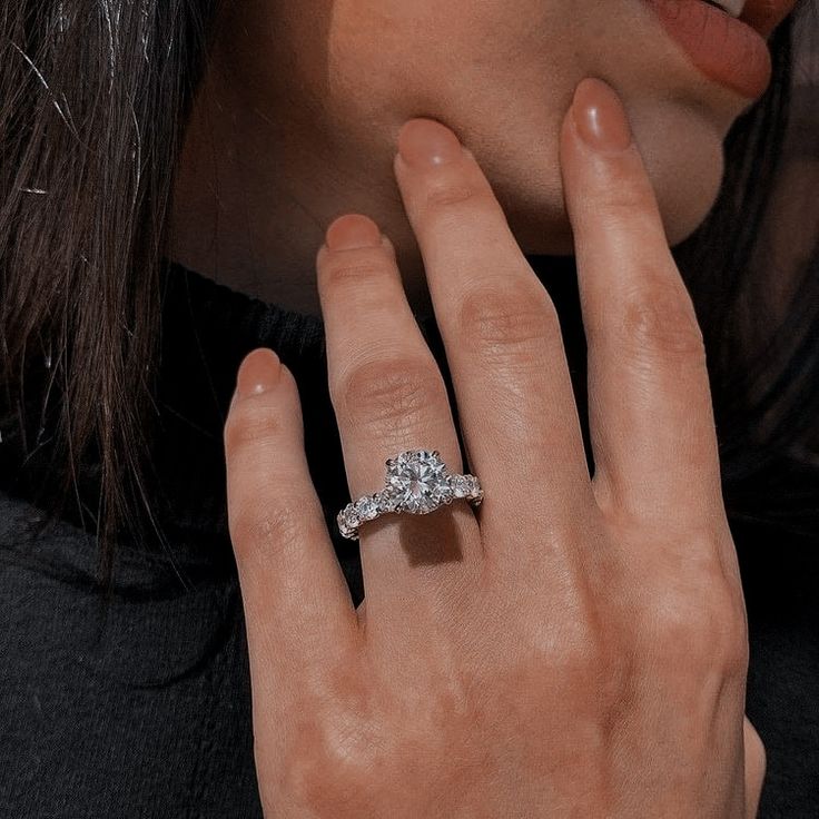 a woman's hand with a diamond ring on it