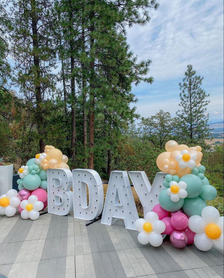 balloons are arranged in the shape of letters that spell out'bday'and flowers