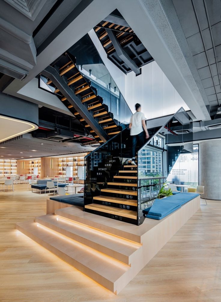 there is a man standing on the stairs in this office building that has been designed to look like a staircase