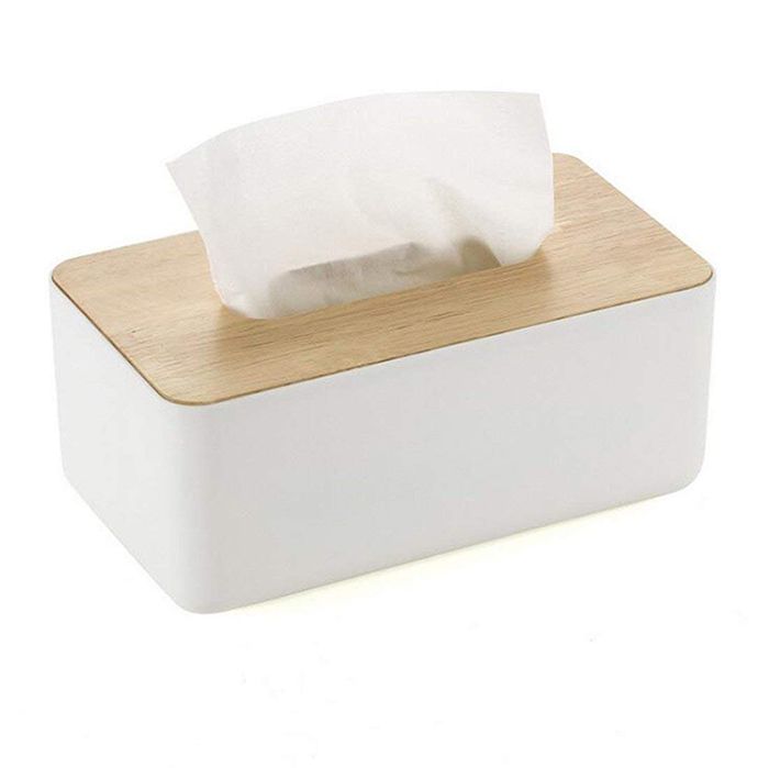 a white tissue dispenser sitting on top of a wooden block