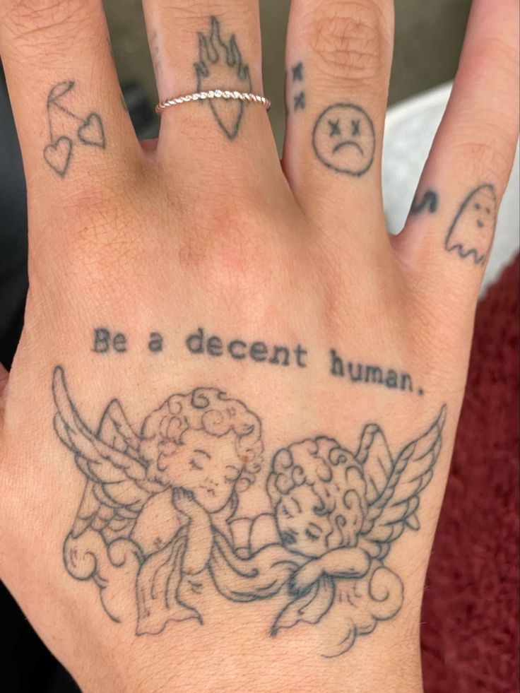 a person's hand with tattoos on it that says, be a decent human