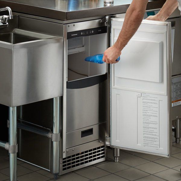 a man is opening the door to his stainless steel kitchen sink and dishwasher