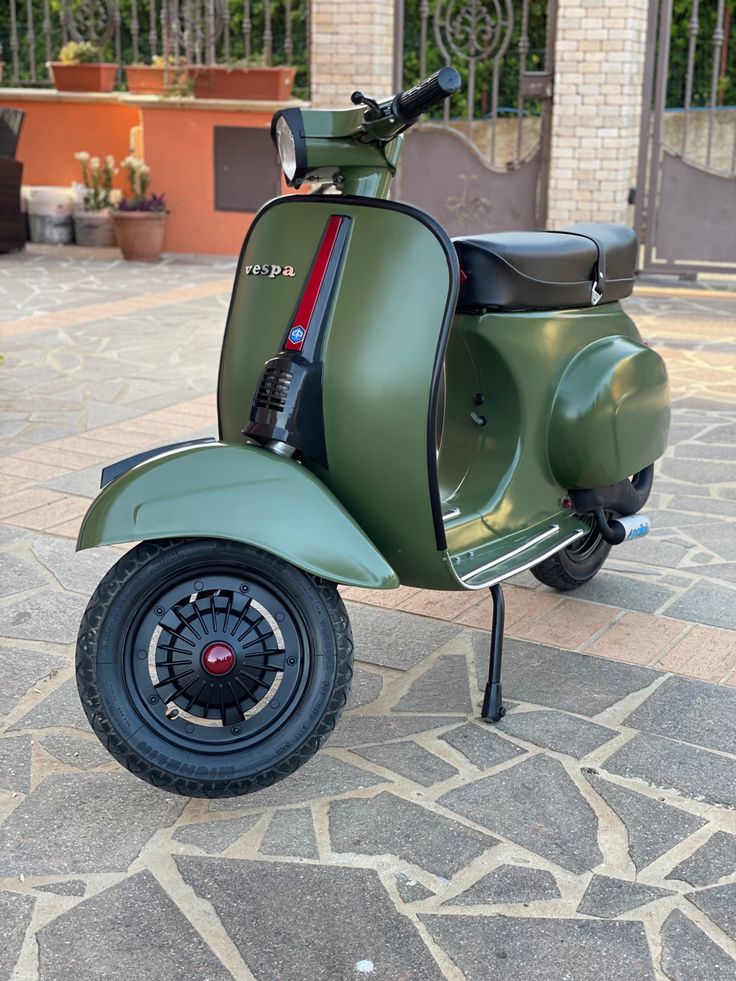 a green scooter parked in front of a building