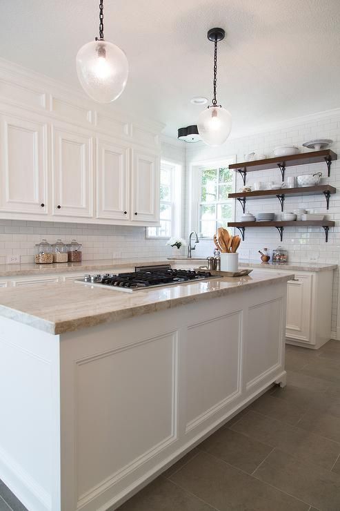 a large kitchen with white cabinets and marble counter tops, along with open shelving on the wall