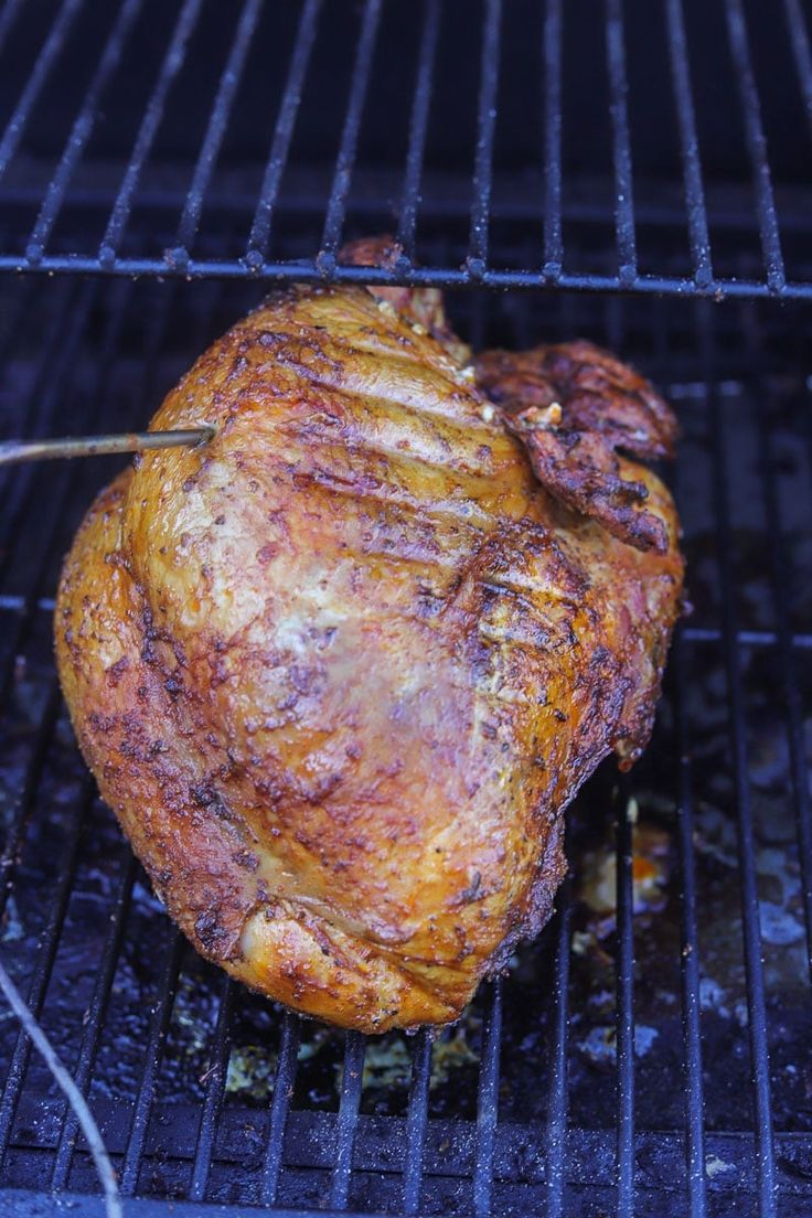 there is a roasting chicken on the grill