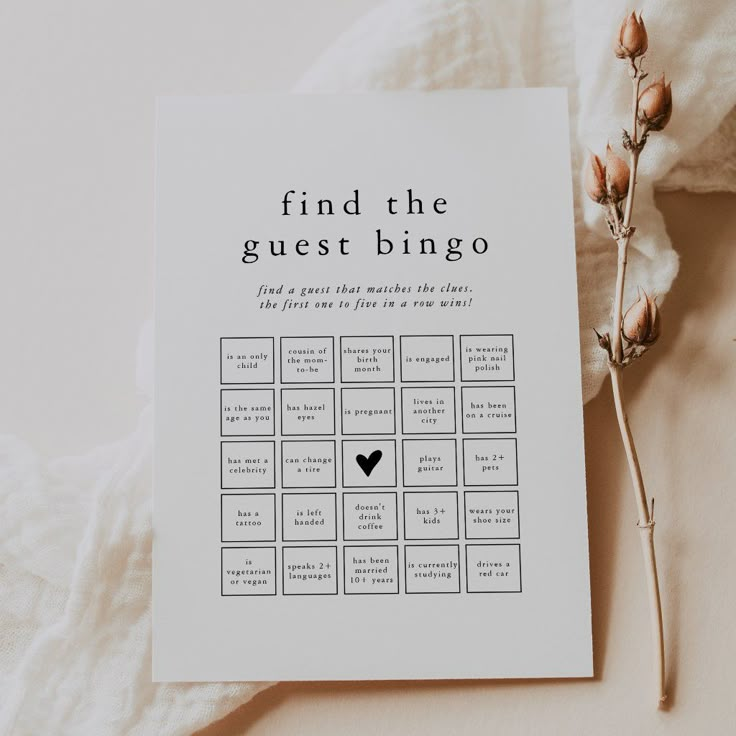 a card with the words find the guest bingo on it next to some dried flowers