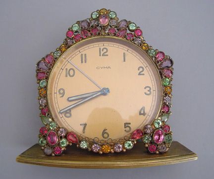 an antique clock is adorned with colorful jewels