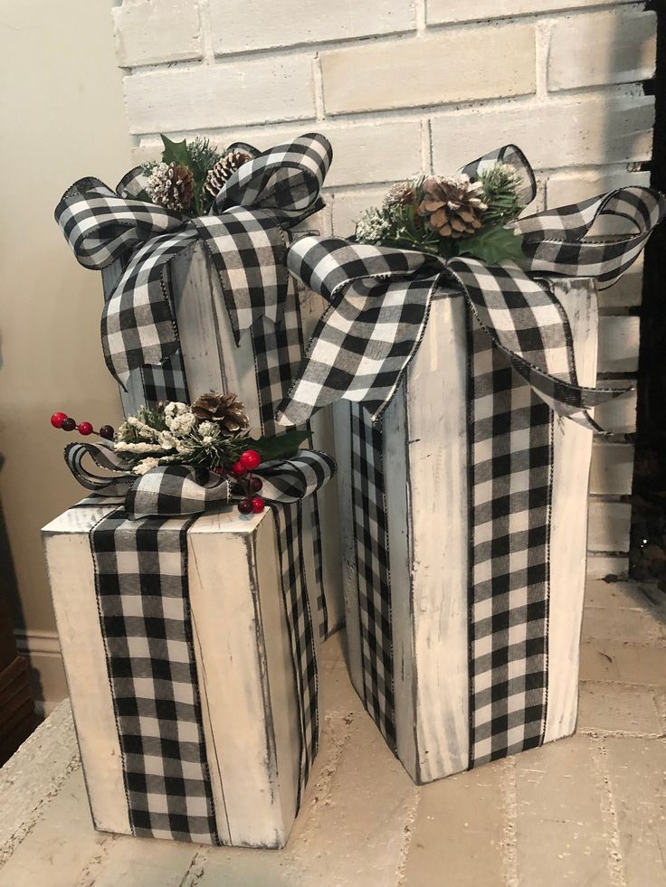 two black and white boxes with bows on them are sitting in front of a fireplace