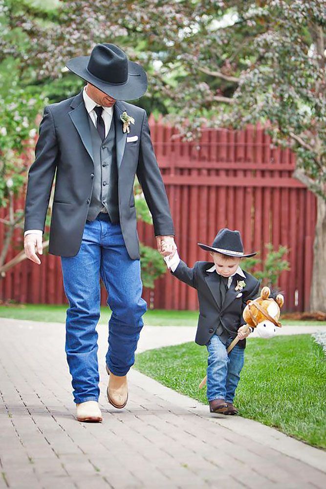 a man in a suit and hat walking with a small boy