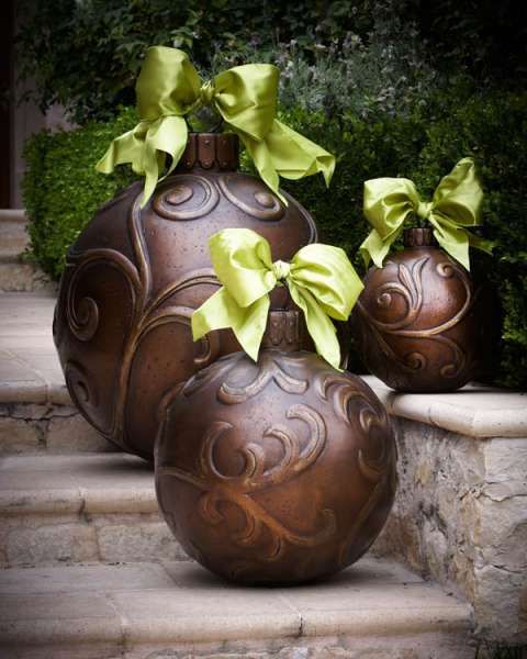 three brown vases with green bows on them are sitting on the steps in front of some bushes