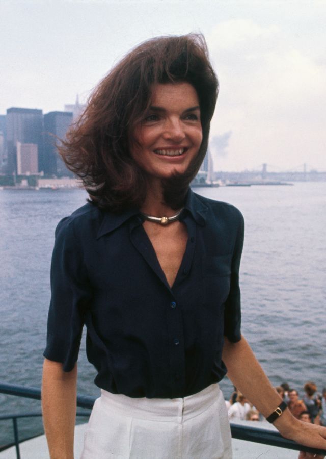 a woman standing on top of a boat near the ocean