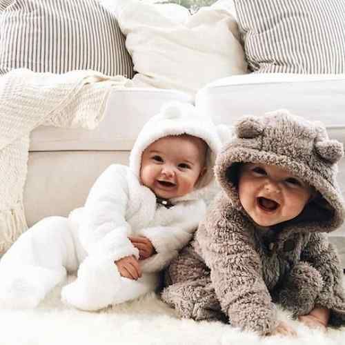 two babies dressed in animal costumes sitting on the floor