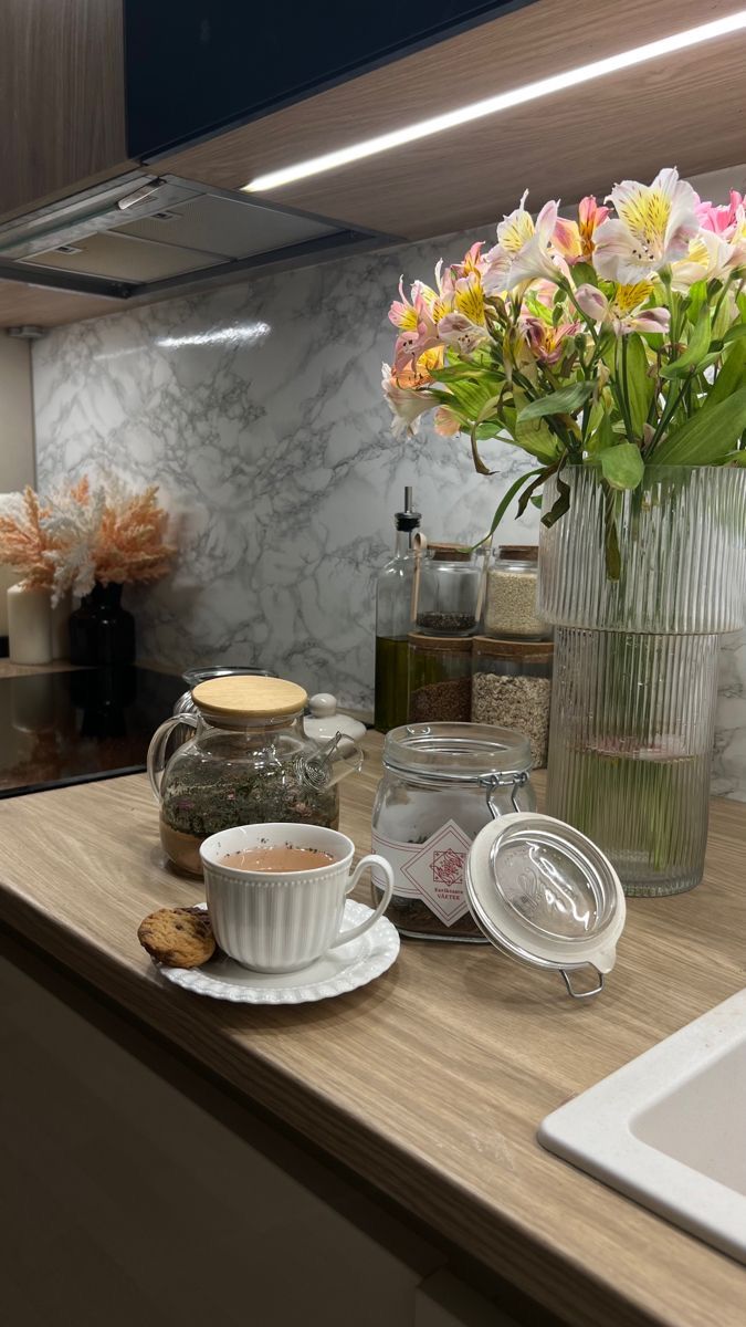 a kitchen counter with flowers in a vase on it