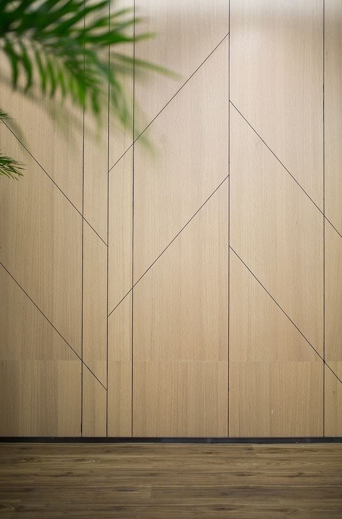 a plant is sitting in front of a wall with wood panels and lines on it