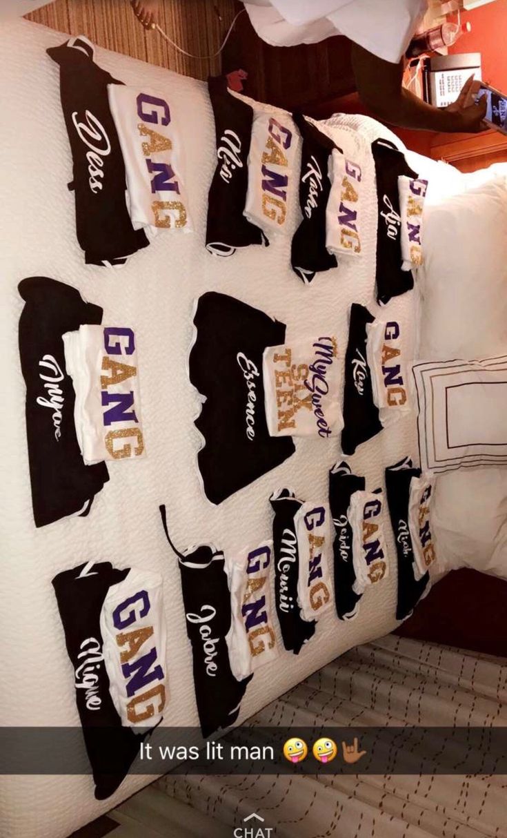 the bed is made up with many t - shirts hanging on it's wall