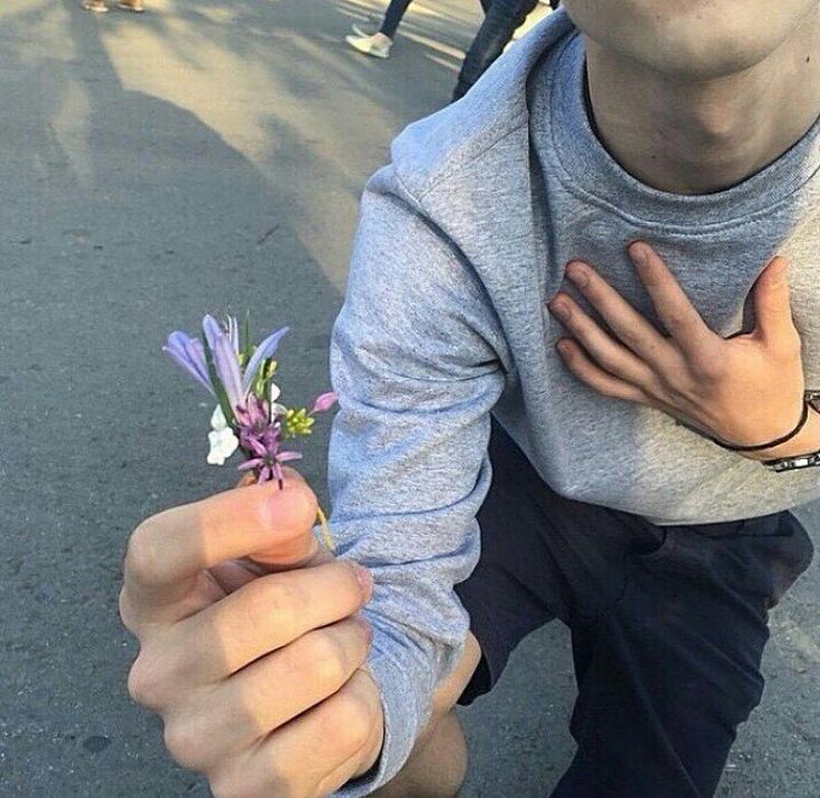 a man kneeling down holding a flower in his left hand with the words on it