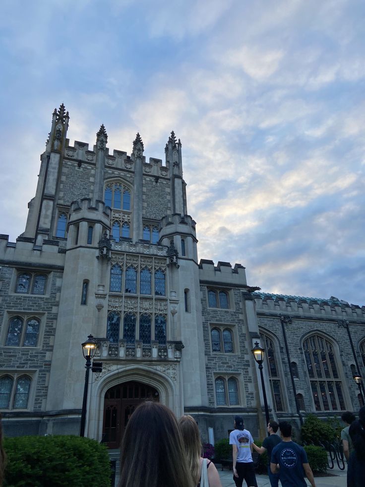 people are walking in front of a large building