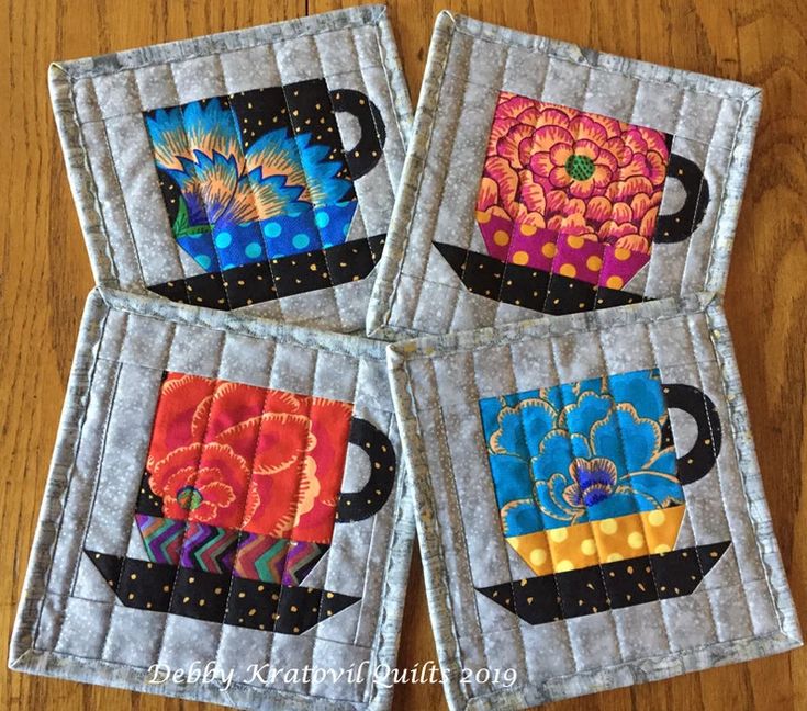 three quilted coasters sitting on top of a wooden table