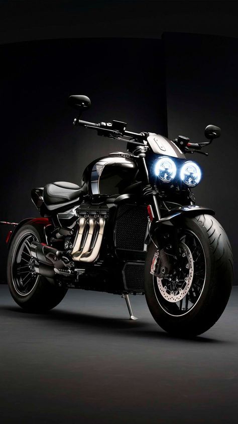 a black motorcycle with two lights on it's headlight is parked in the dark