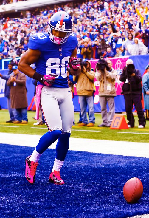 a football player running on the field with a ball in front of him and people watching