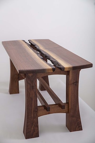 a wooden table with two pieces of wood sitting on it's legs and one piece of metal sticking out of the top