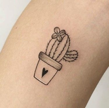 a small cactus in a pot tattoo on the right thigh, with a heart at the bottom