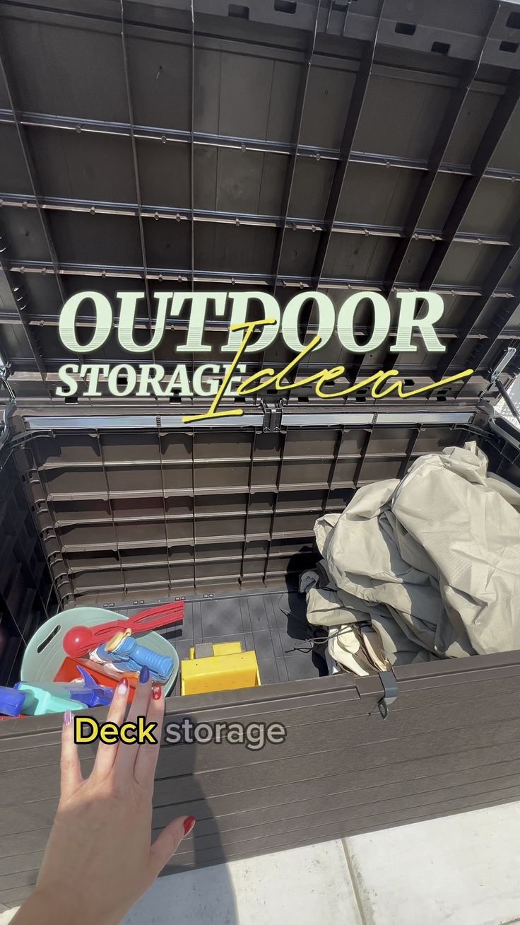 a person holding a toy in front of an outdoor storage bin with other items inside