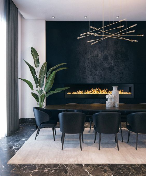 a dining room table with black chairs and a fireplace