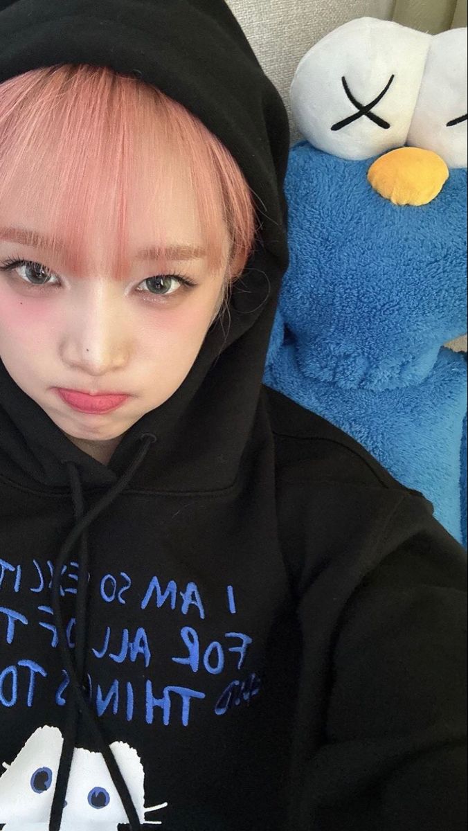 a girl with pink hair wearing a black hoodie