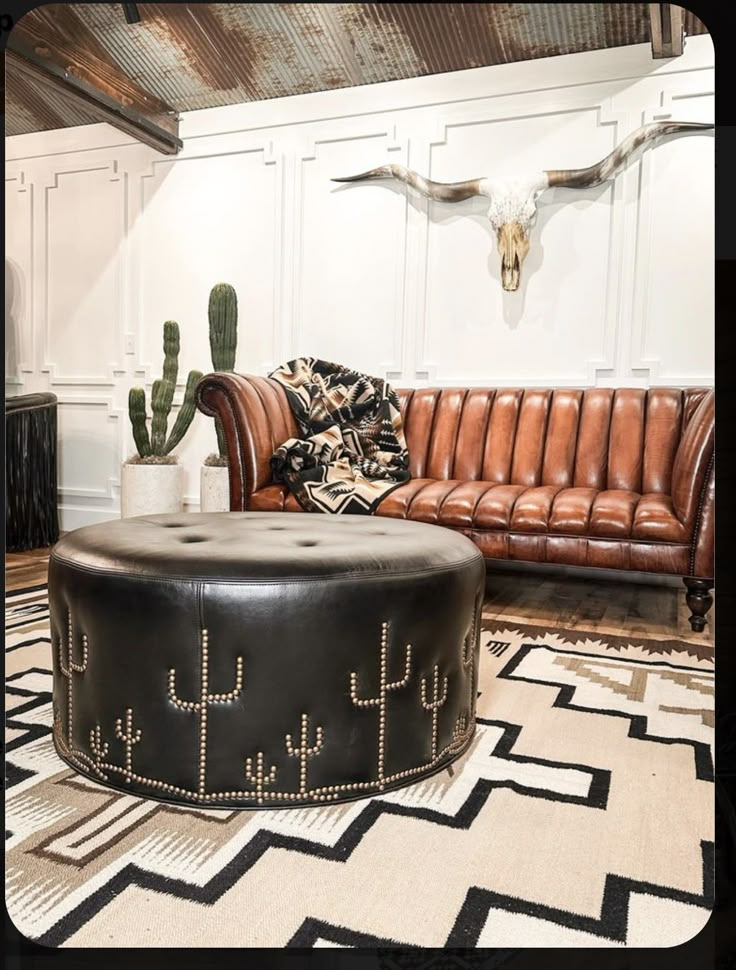 a living room filled with furniture and a cow skull on the wall