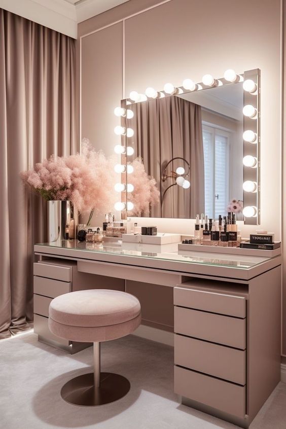 a vanity with lights, stool and mirror in a room that has curtains on the windows