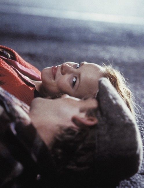 a young woman laying on the ground with her head down and eyes closed, looking up