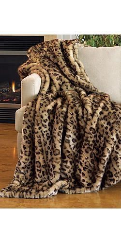 a leopard print blanket on a couch in front of a fireplace