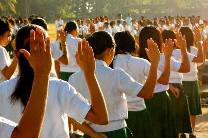 a group of young women standing next to each other holding their hands up in the air