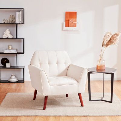 a white chair sitting on top of a hard wood floor next to a glass table