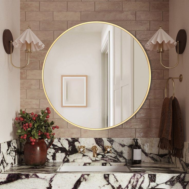 a bathroom with marble counter tops and a round mirror on the wall above it, along with a potted plant