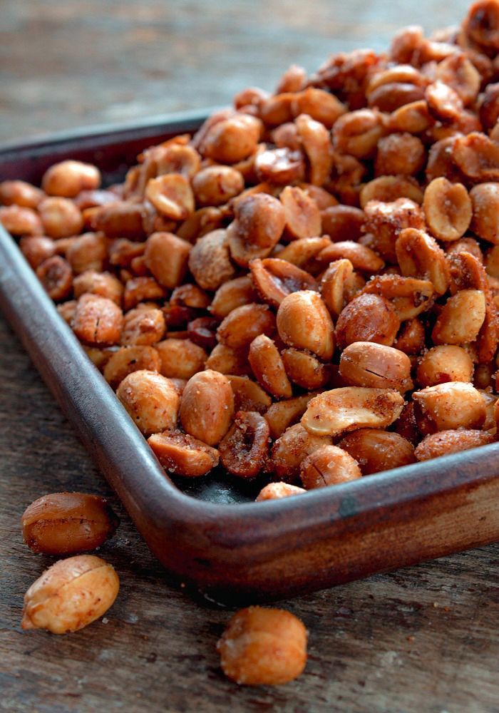 roasted peanuts in a pan with the words spiced peanut snack