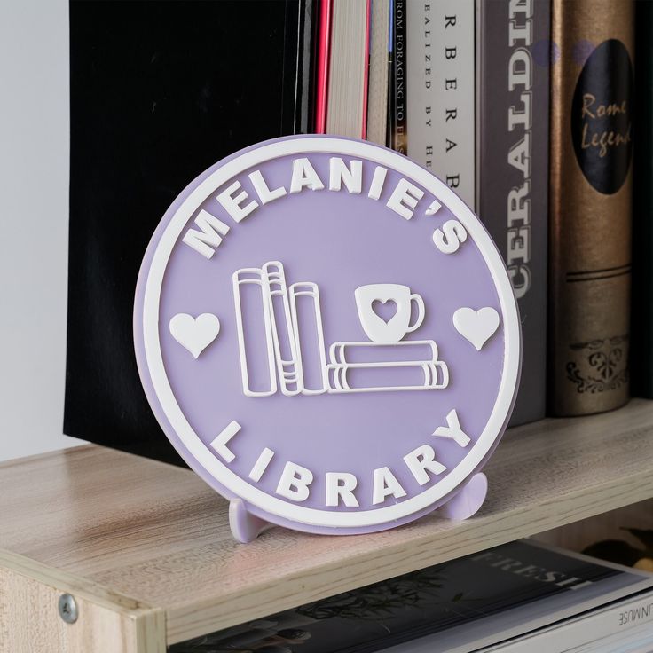 a purple sign that says melanie's library on top of a book shelf