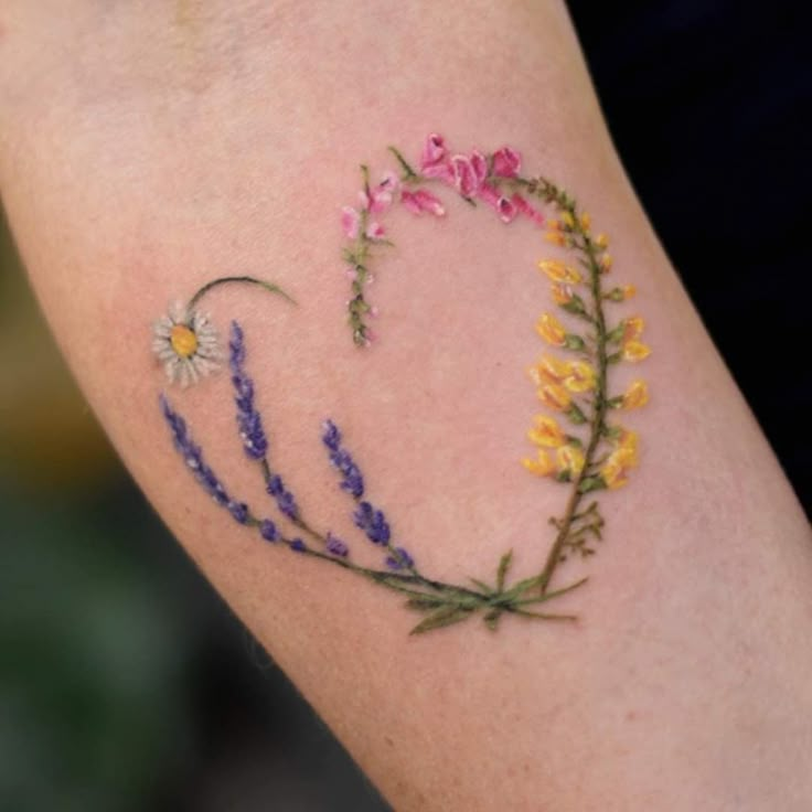 a woman's arm with flowers painted on it and the word love written in small letters