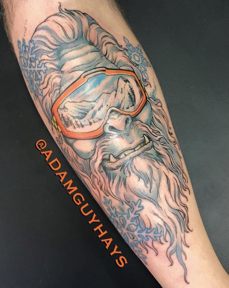 a man's leg with a tattoo on it that has an image of a lion wearing goggles